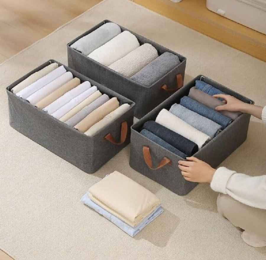 Clothes being sorted into the grey storage boxes
